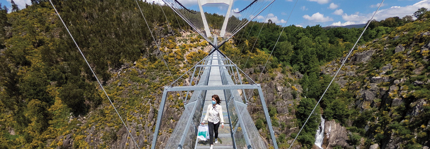 Woman walking across a bridge.