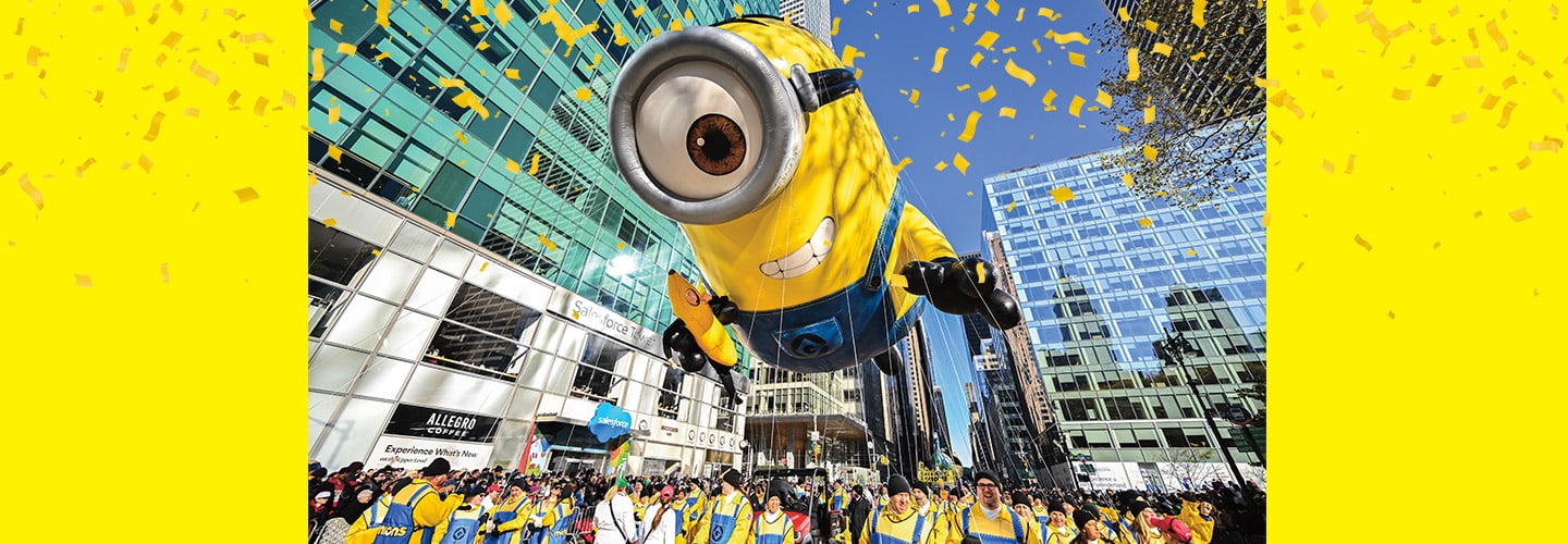 a balloon of a minion soaring over a crowd